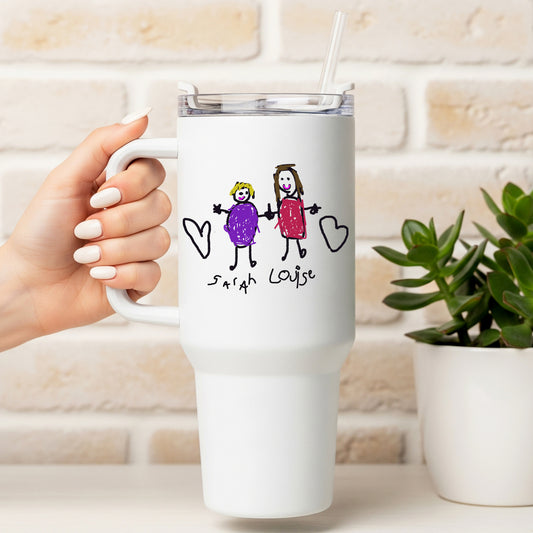 White travel mug with a hand-drawn design of two people holding hands and hearts, held by a hand against a light-colored brick wall. | Little Heirloom