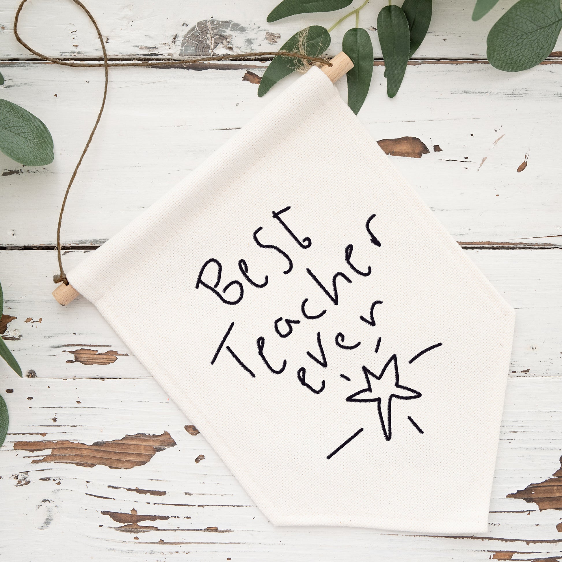 Whiteboard with 'Best Teacher Ever' text on a rustic wooden surface with greenery. | Little Heirloom