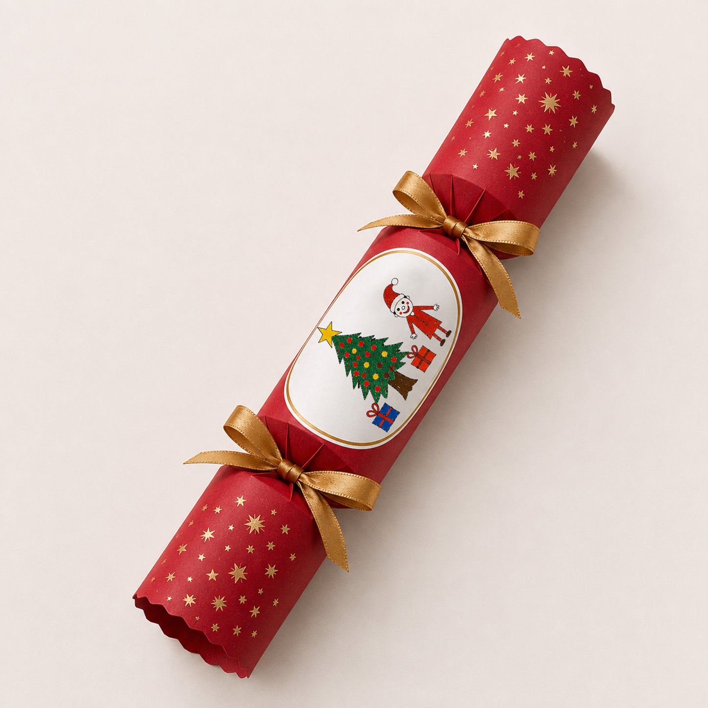 A red Christmas paper cracker with gold star patterns, tied with two gold ribbons, and featuring a child's drawing | Little Heirloom