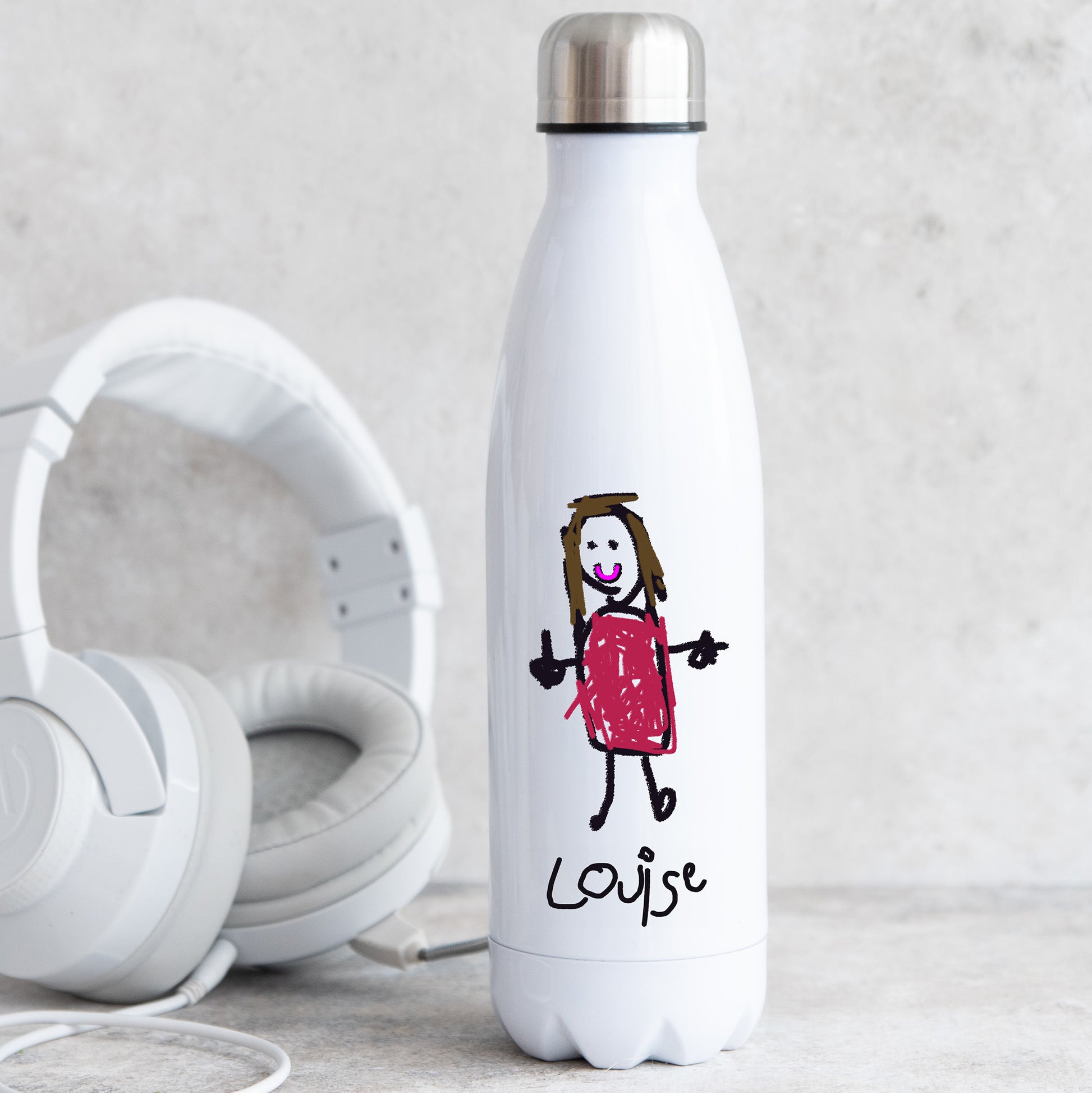 White water bottle with a child's drawing of a girl in a red dress and the name 'Louise', next to white headphones on a light gray background. | Little Heirloom
