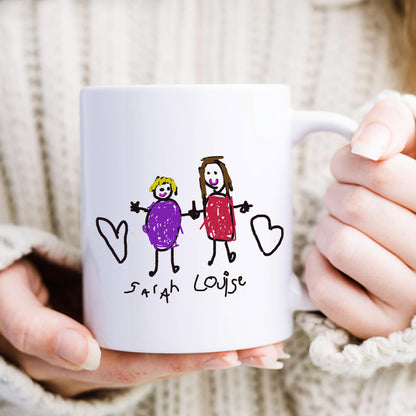White mug held by hands with stick figure drawing of two people and 'Sarah Louise' text. | Little Heirloom
