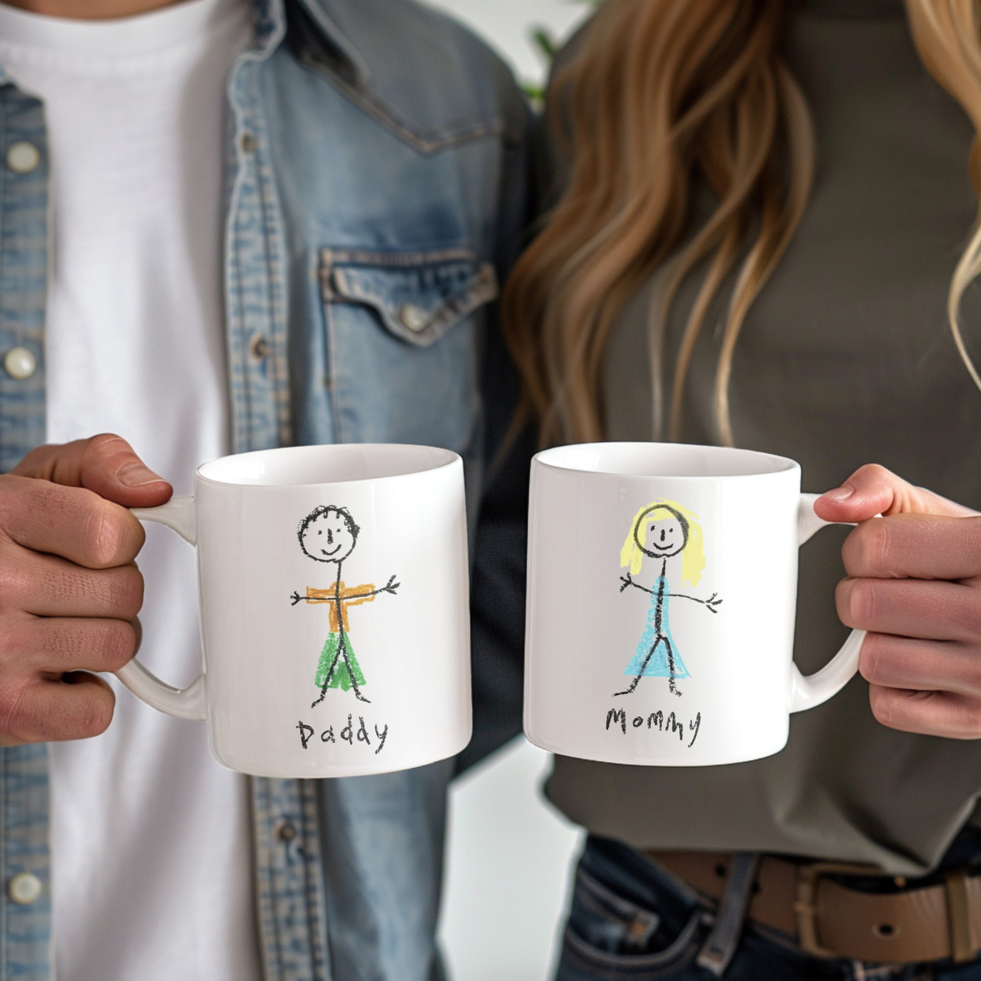 Two people holding mugs with stick figure drawings labeled 'Daddy' and 'Mommy'.  | little heirloom