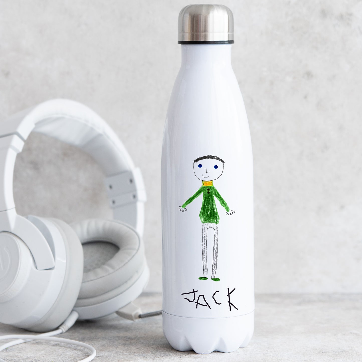White water bottle with a drawing of a person and the name 'Jack', next to white headphones on a light gray background. | Little Heirloom | Little Heirloom
