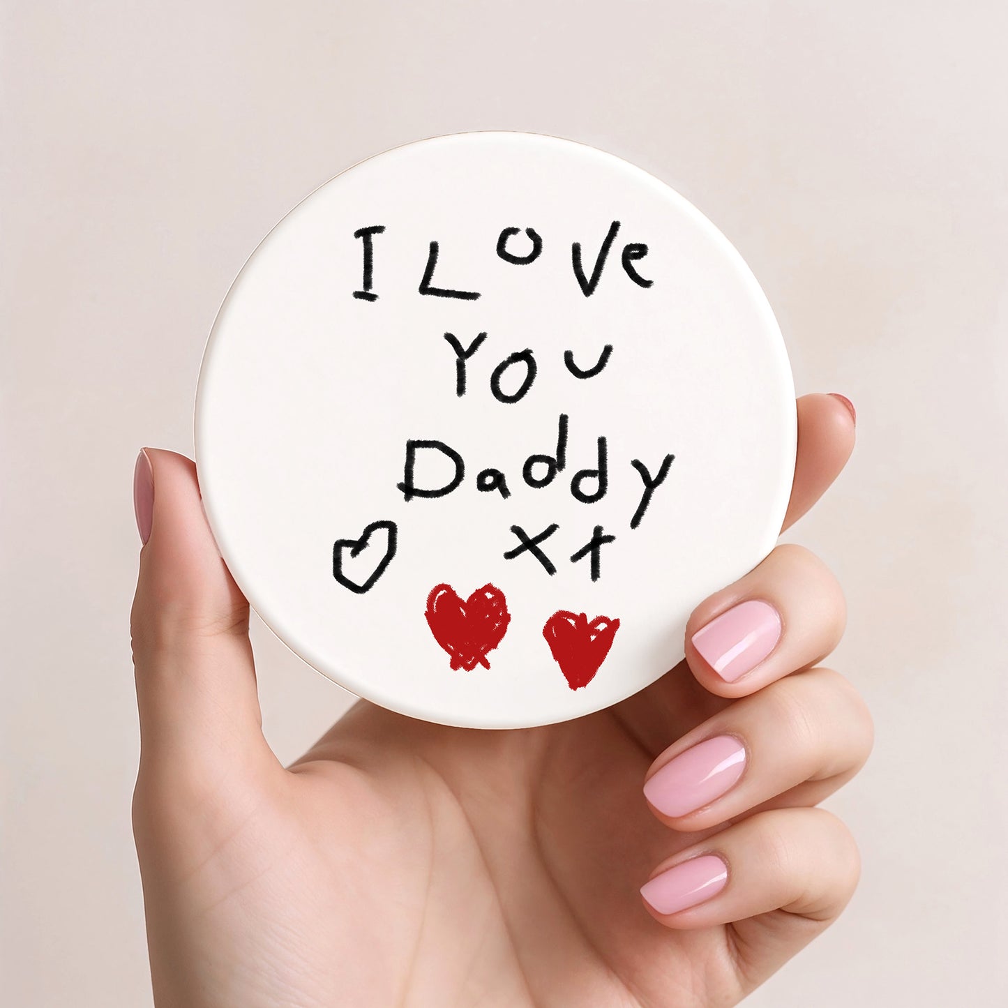 Hand holding a round white coaster with 'I Love You Daddy' text and heart symbols. | Little Heirloom