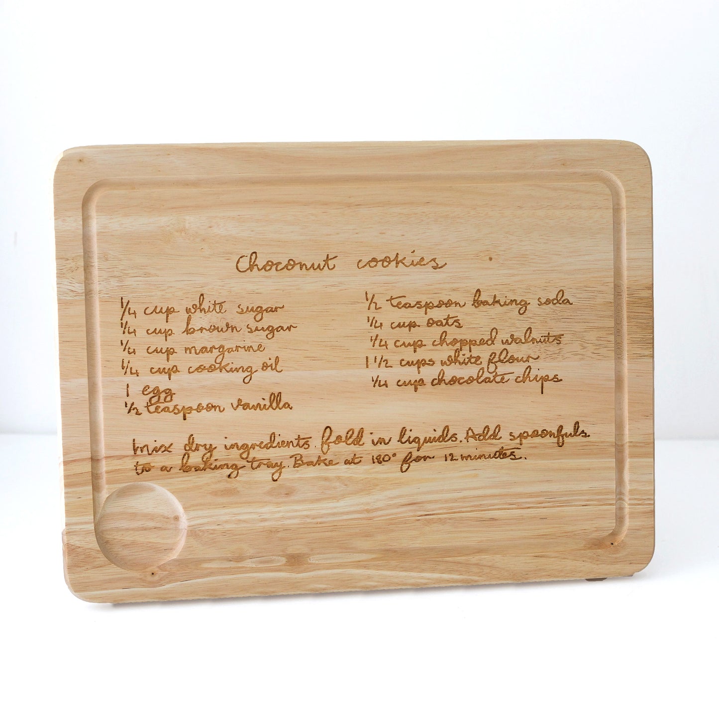Wooden cutting board with engraved coconut cookies recipe on a white background | Little Heirloom
