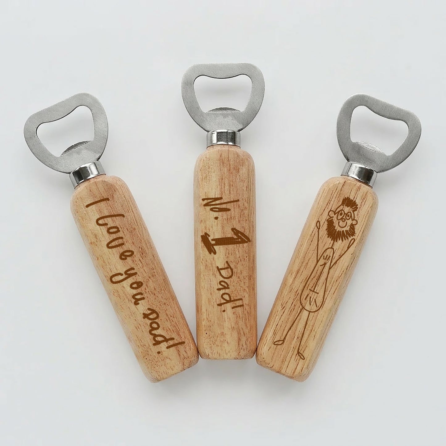Three wooden bottle openers with engraved with children's writing on a white background | Little Heirloom