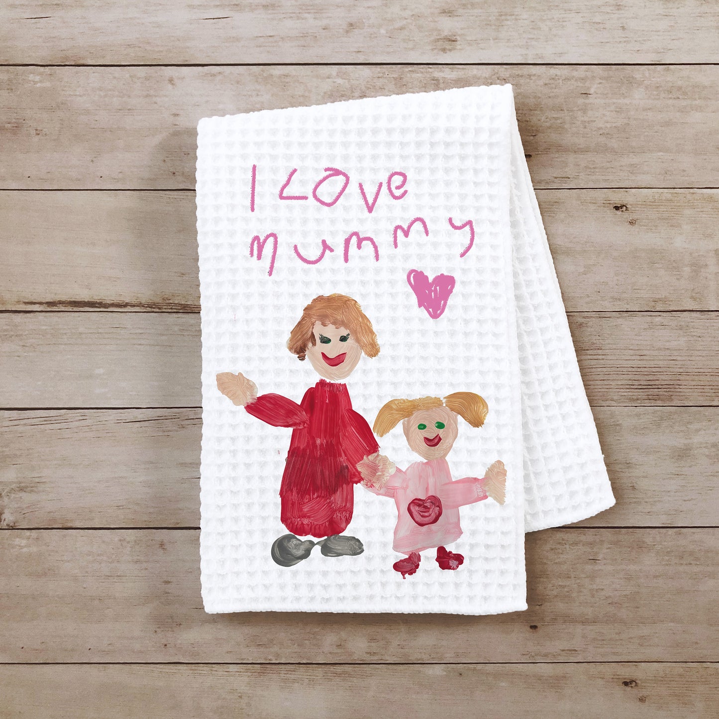 White towel with hand-drawn illustration of a mother and child holding hands and 'I love mummy' text on a wooden surface | Little Heirloom