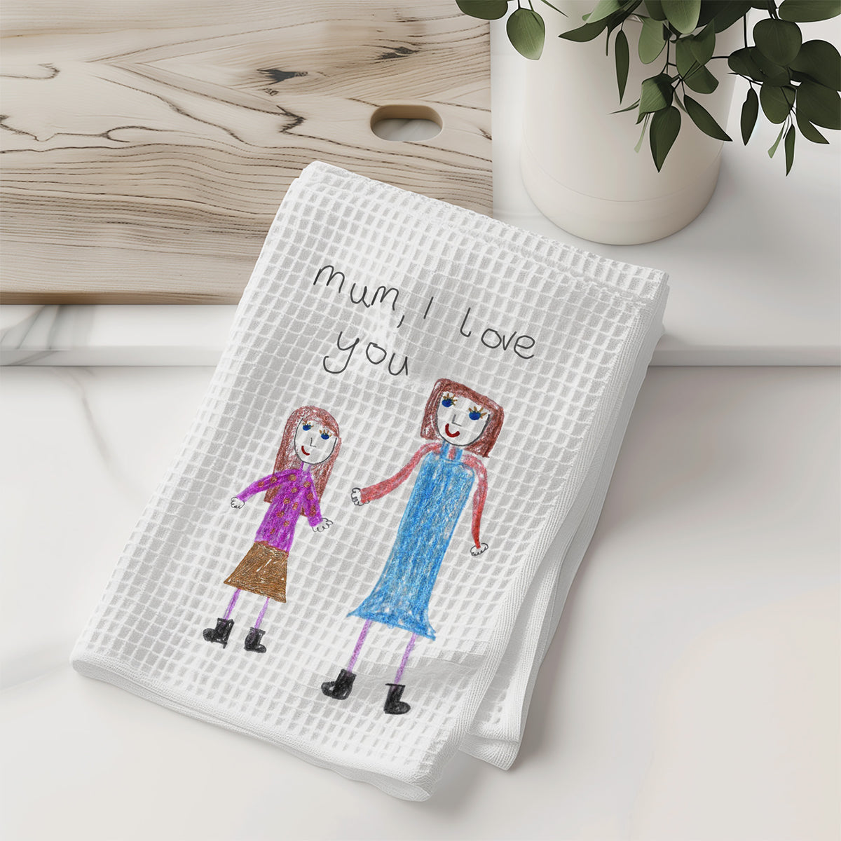 White towel with children's drawing of two girls and 'Mum, I love you' text on a wooden surface | Gift for Mums | Little Heirloom