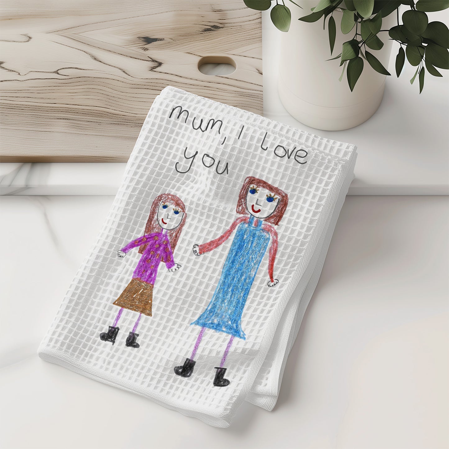 White towel with children's drawing of two girls and 'Mum, I love you' text on a wooden surface | Gift for Mums | Little Heirloom