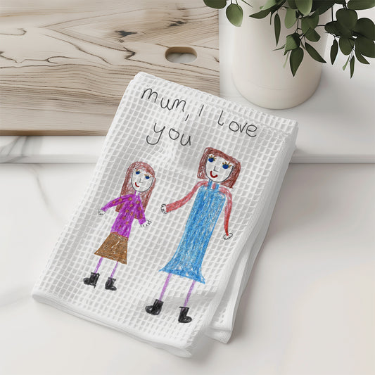 White towel with children's drawing of two girls and 'Mum, I love you' text on a wooden surface | Gift for Mums | Little Heirloom
